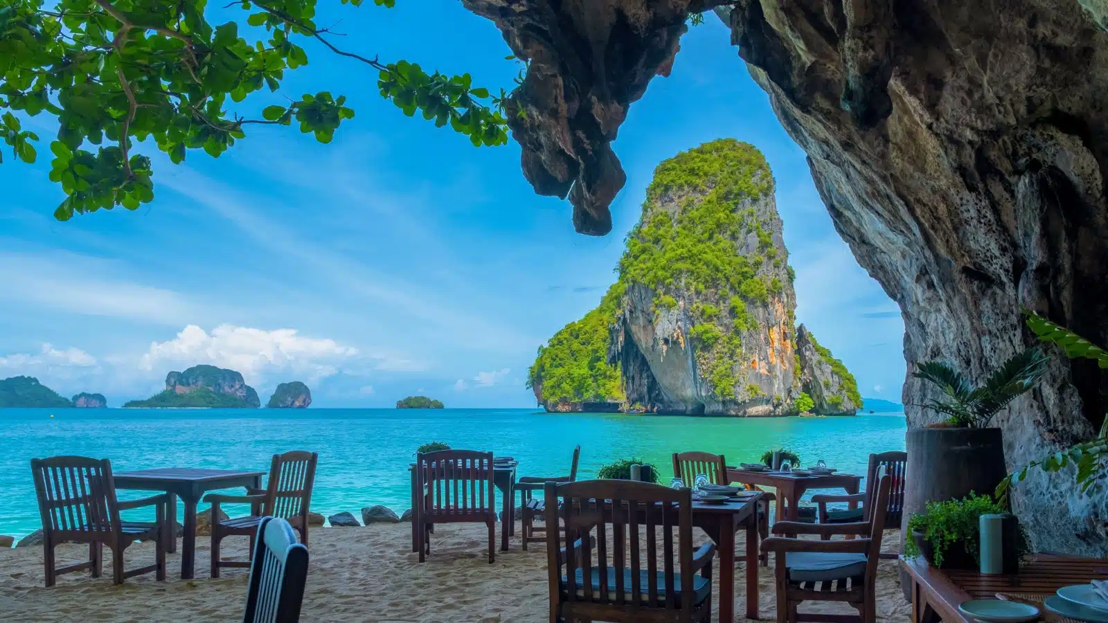 Cafe tables near the hotel on Railay Beach in Krabi Thailand, with a view of the bay.