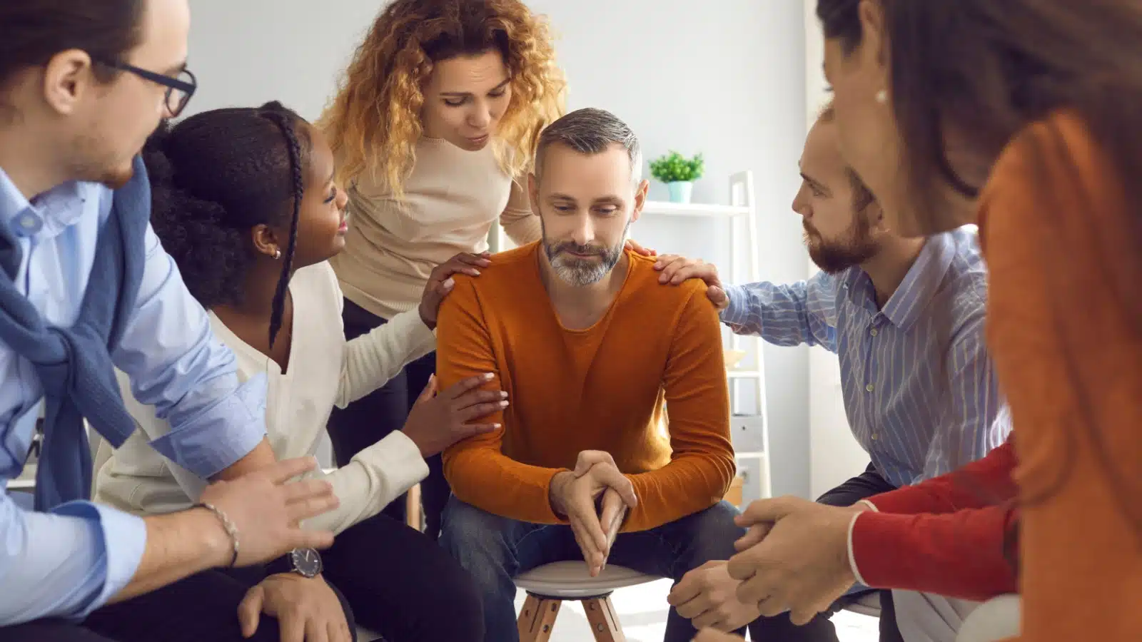 Members of a group therapy session show compassion and support to each other.