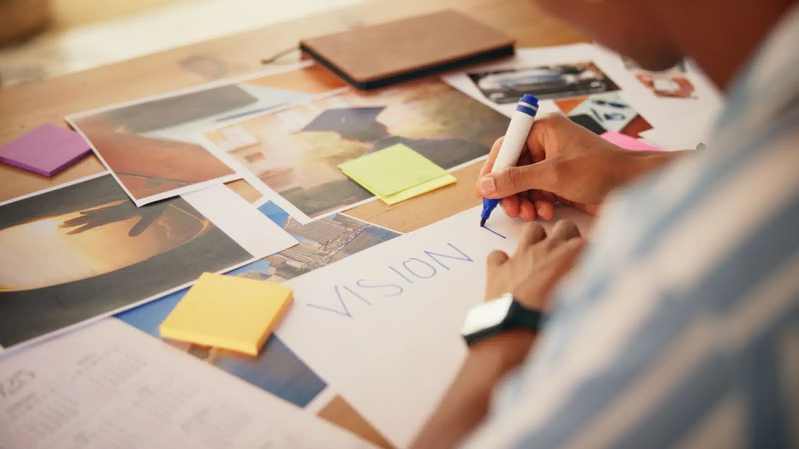Close up of hands creating a vision board.