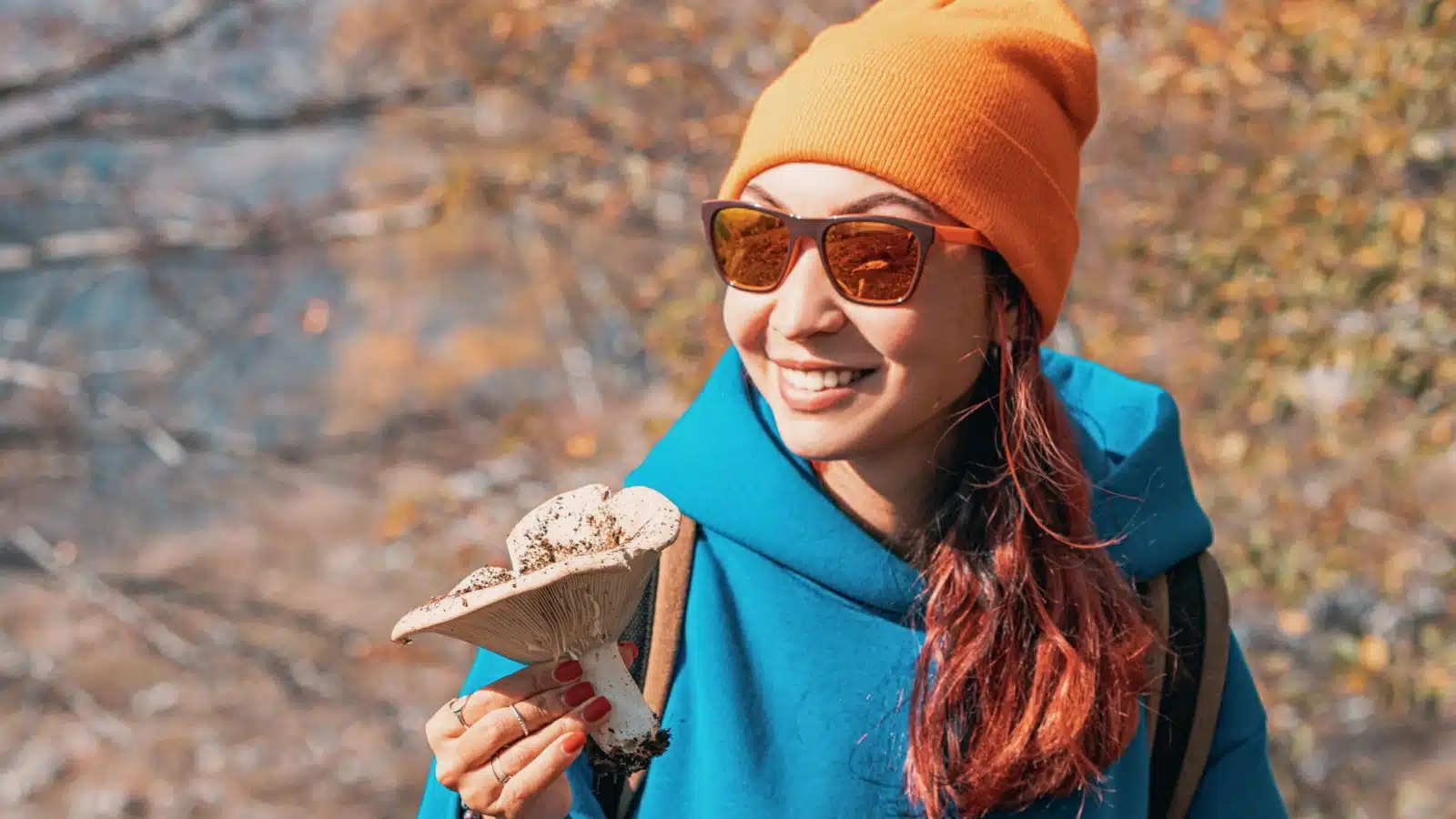 A woman holds a mushroom she foraged.