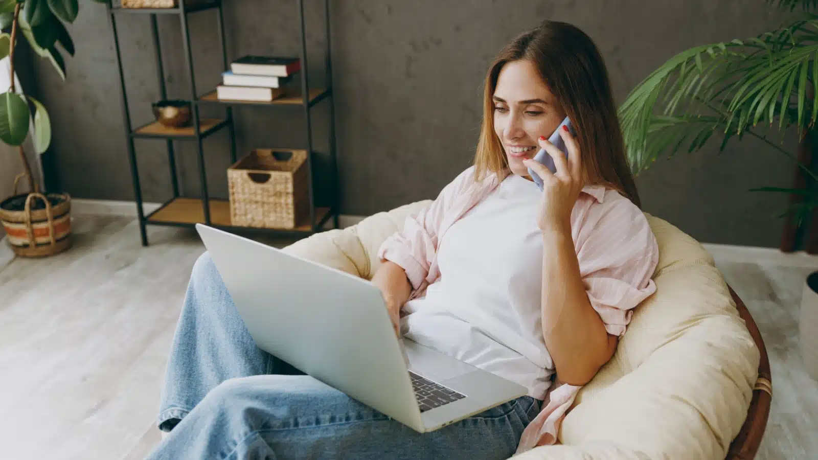 A freelancer works on her laptop in a cozy bean bag chair.