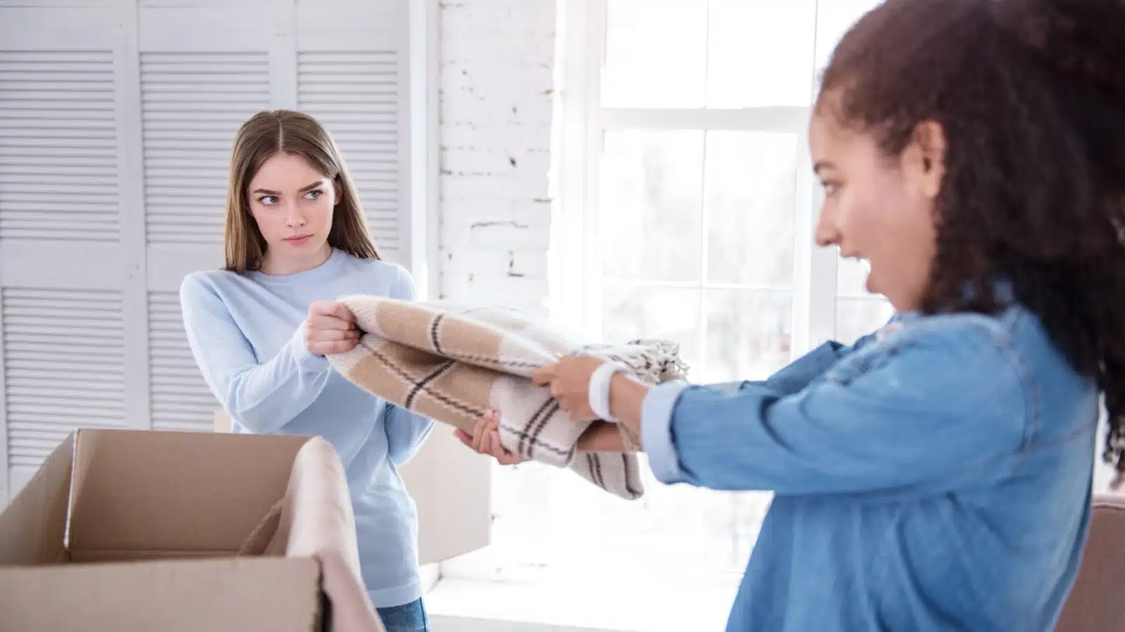 Two friends fighting over a scarf to illustrate when it's not okay to be selfish.