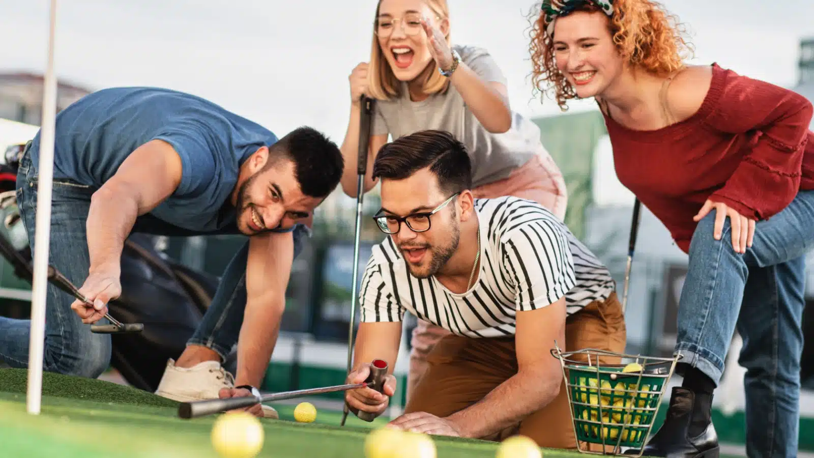 Friends measuring distance on a mini golf course.