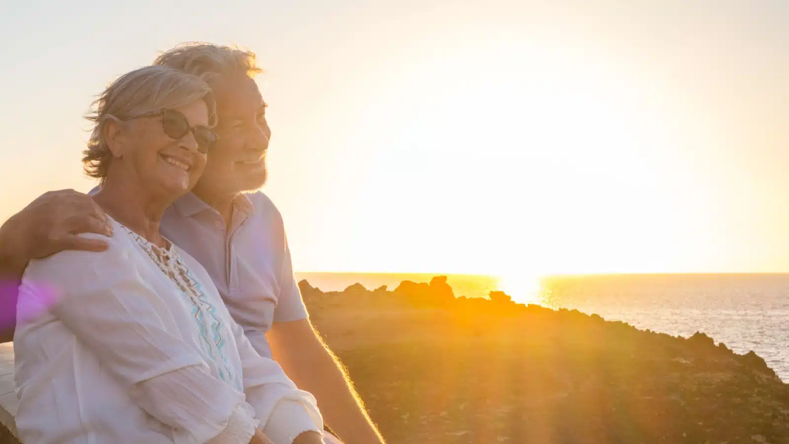 A happy senior couple enjoys a lovely sunset.