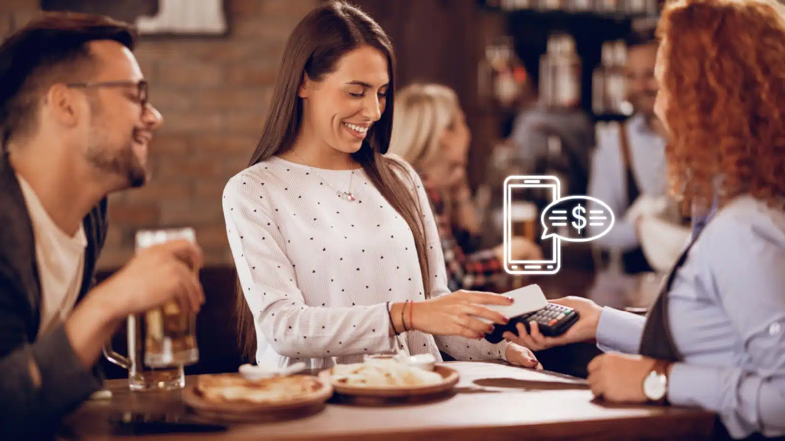 A happy woman pays her bill at a restaurant.