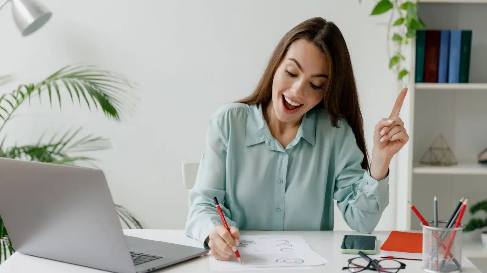 A happy woman has an idea and starts working on it.