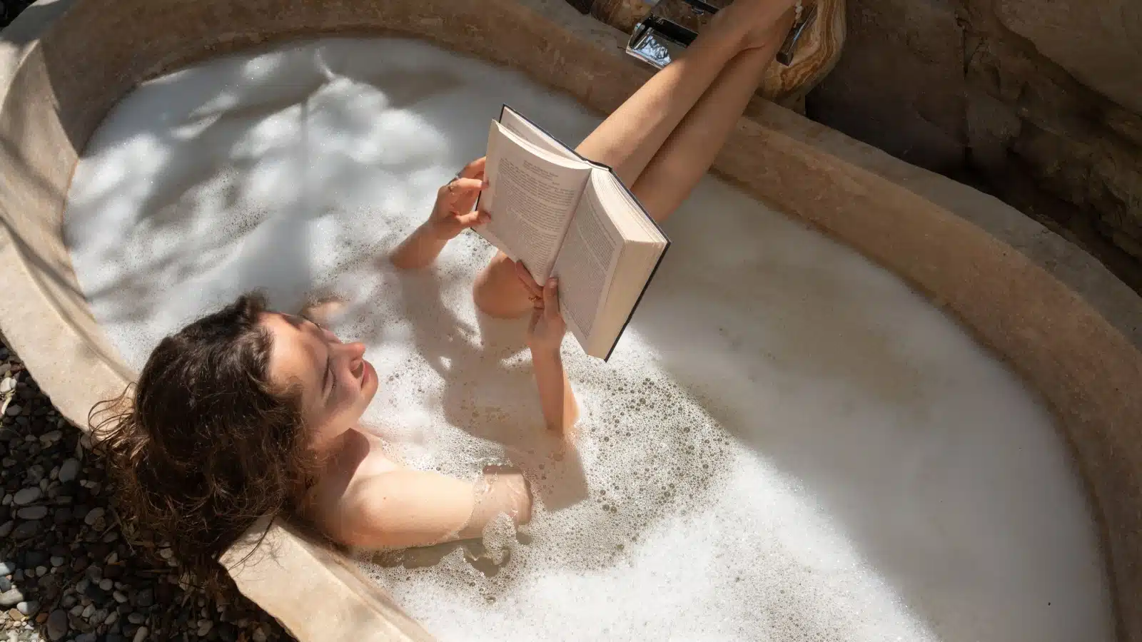A woman indulges in a cozy bubble bath.