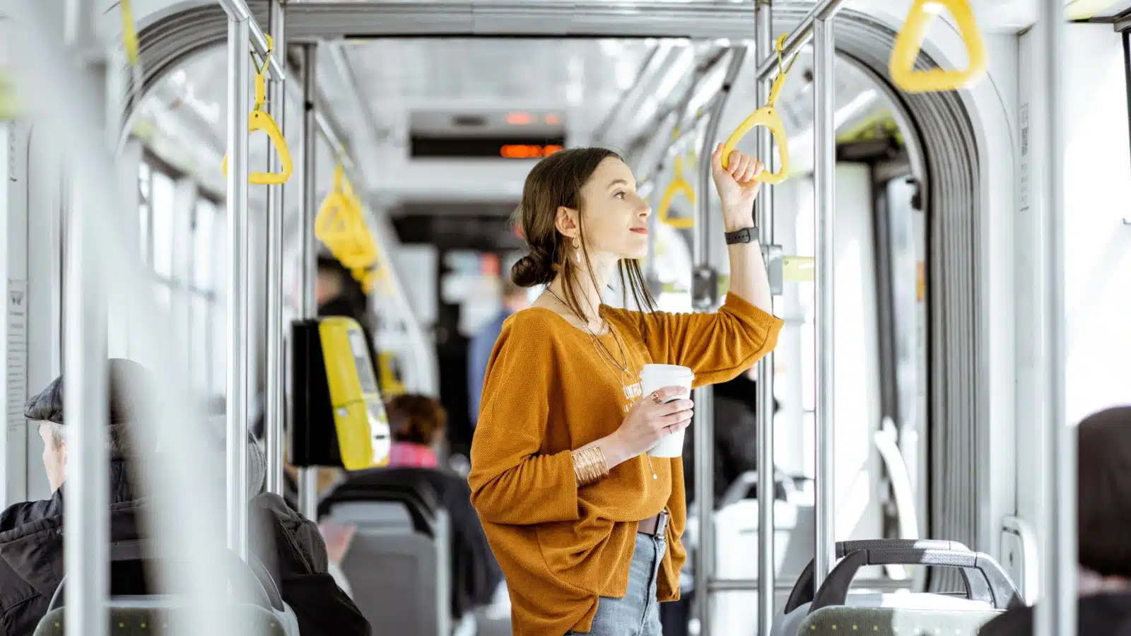 A woman stands on a train for public transportation. 