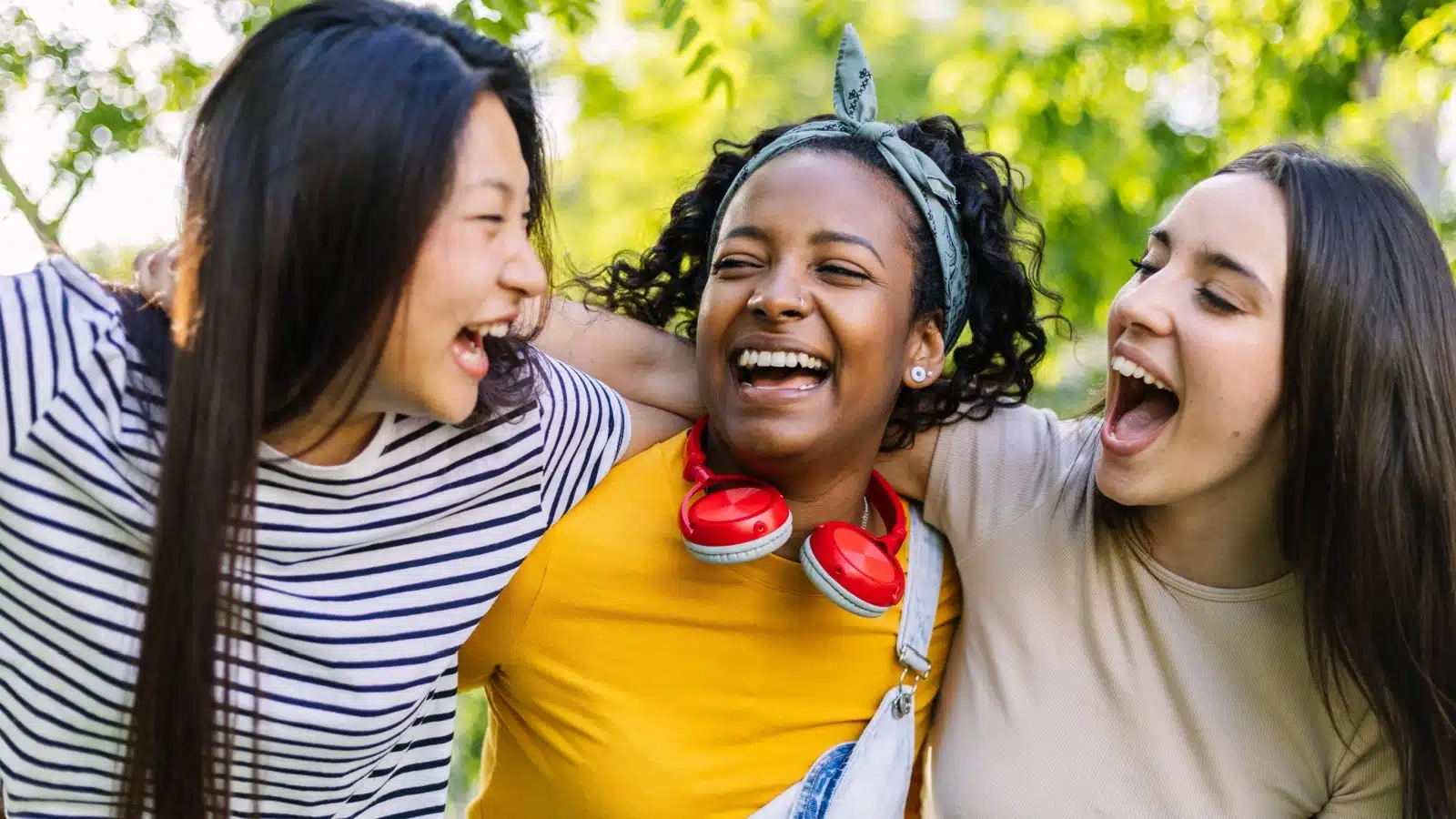 Three happy friends laughing together.