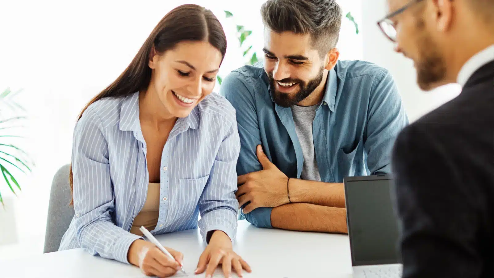 A woman happily signs a contract.