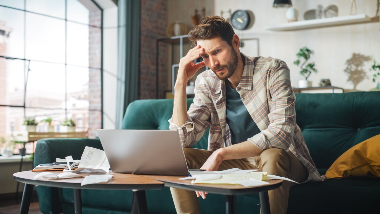A man stresses about money while trying to pay his bills.