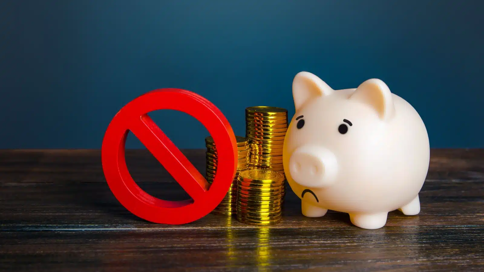 A red "no" sign stands in front of a sad looking piggy bank and pile of coins to represent the unbanked.