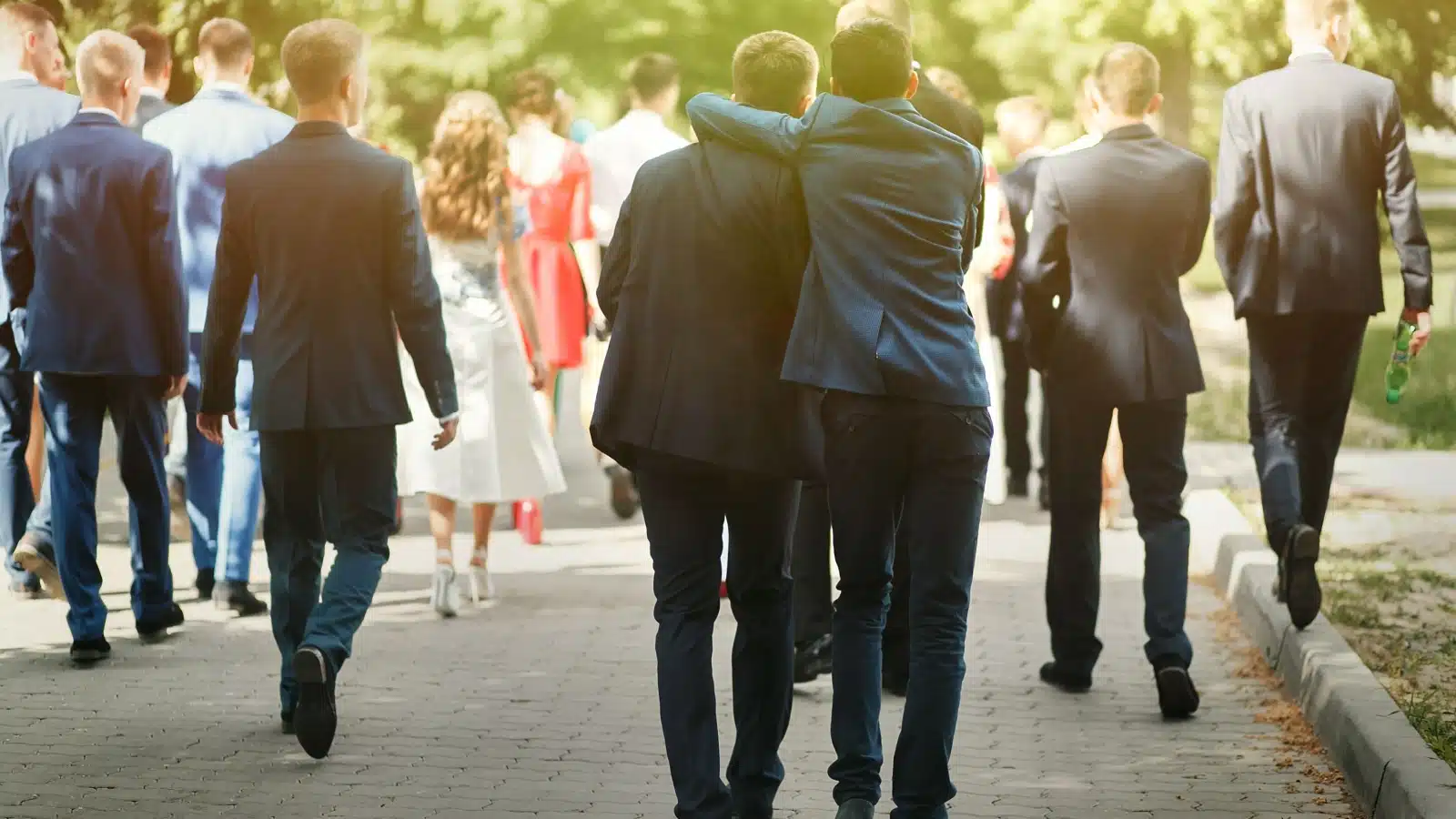 Rear view of wealthy, well dressed college students walking way.