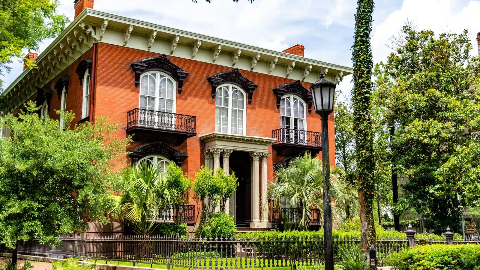 The Mercer Williams House surrounded by trees in Savannah, GA.