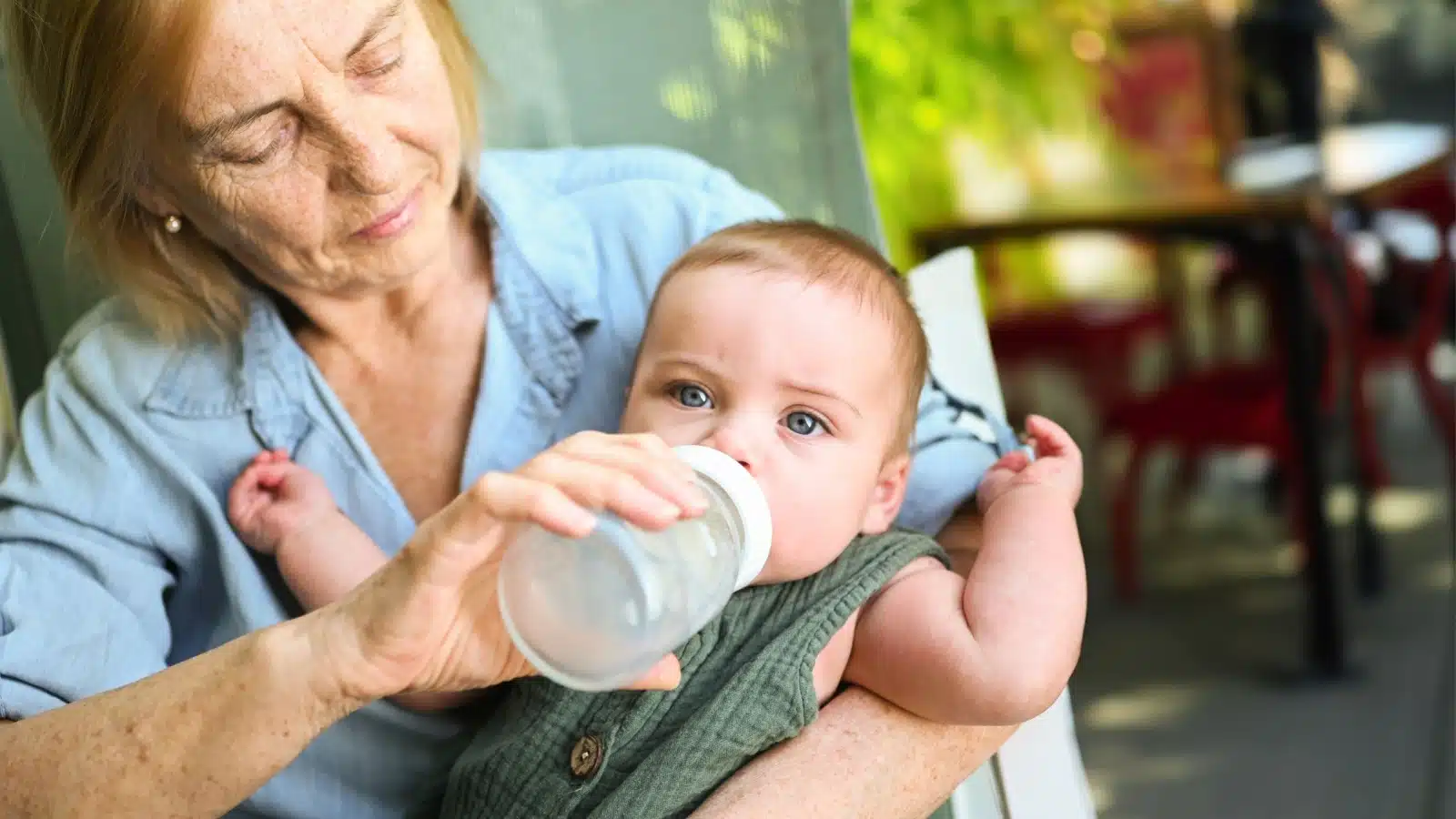 A grandma bobble feeding an infant to represent how women's unpaid labor made the village.