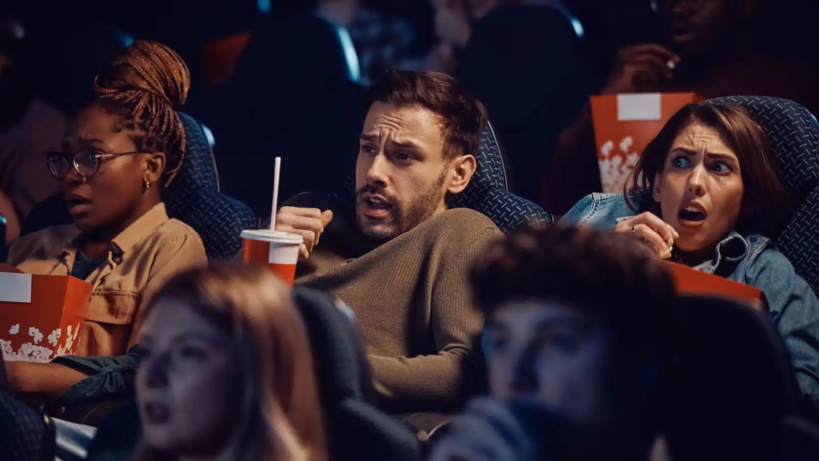 Guests watching a horror film screening at a horror convention.