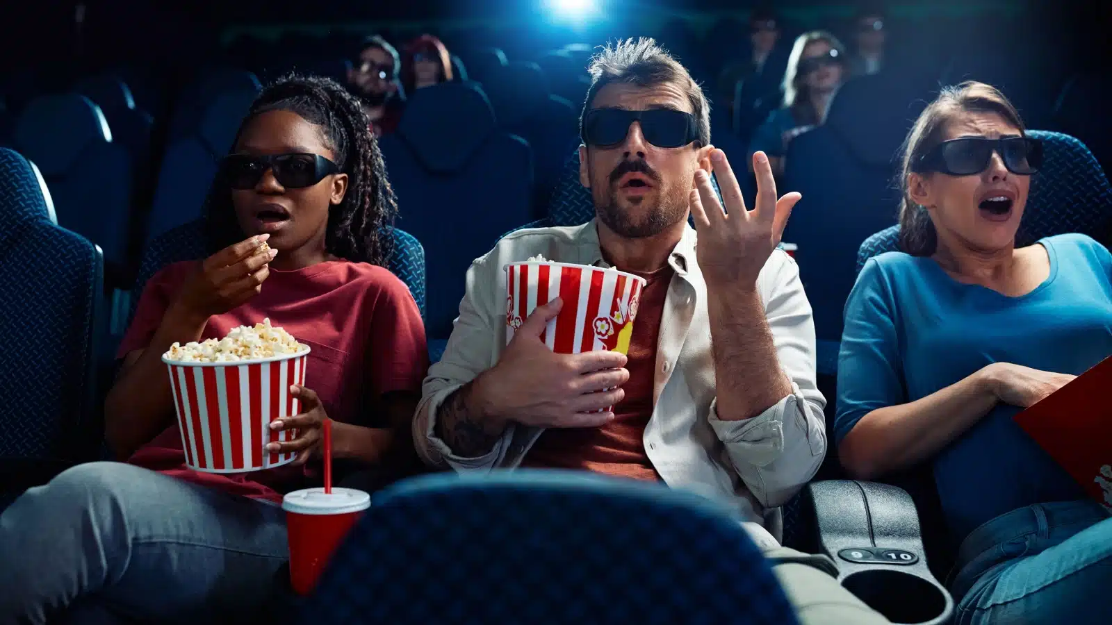 Guests watching a horror movie in a theater to represent a horror film festival.