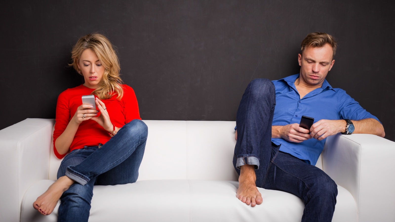 A couple sitting on the couch ignoring each other, looking at their phones instead, to represent things the internet ruined.