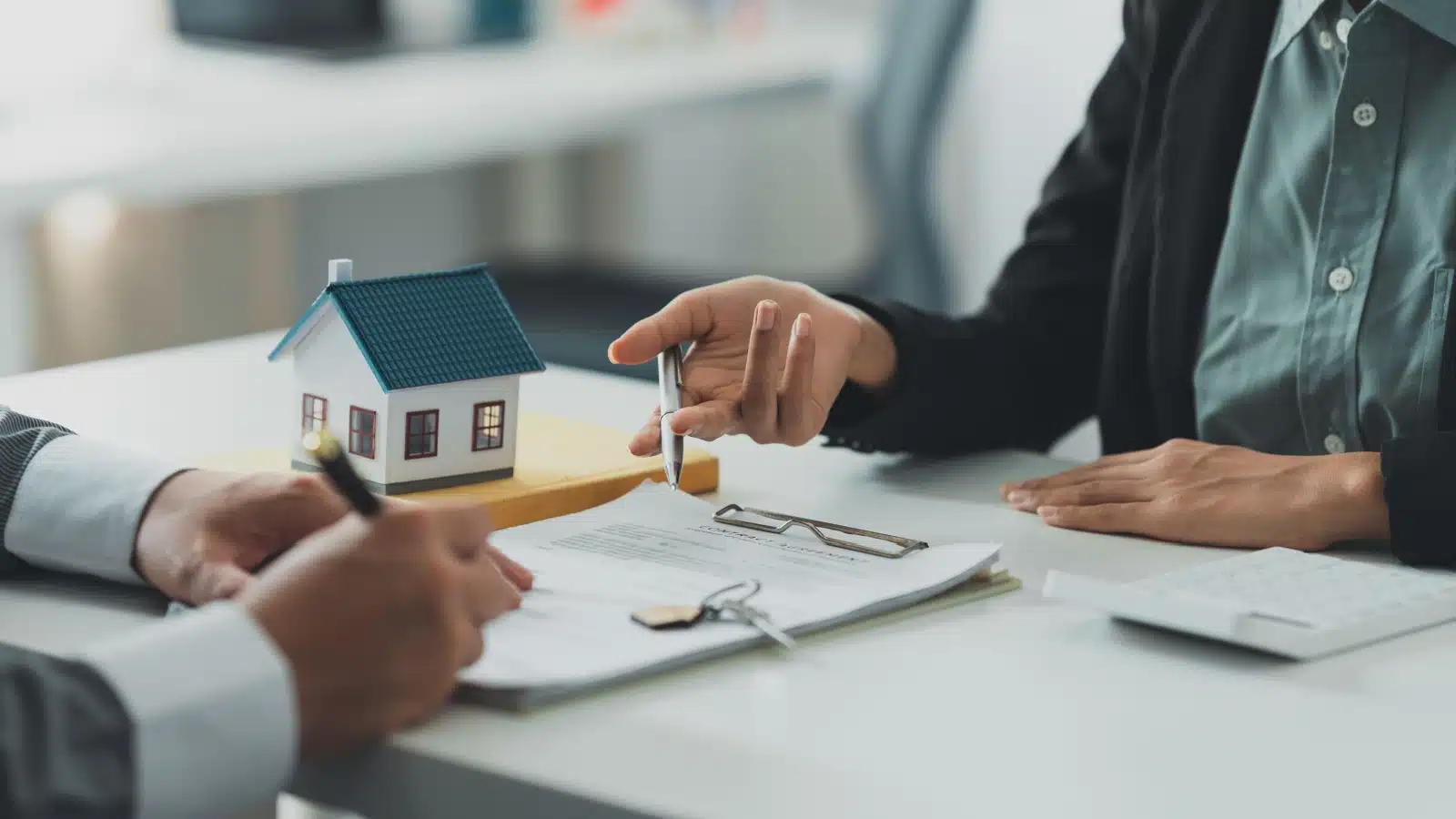 The buyer signing all the closing paperwork for buying a house, to represent closing costs on real estate.
