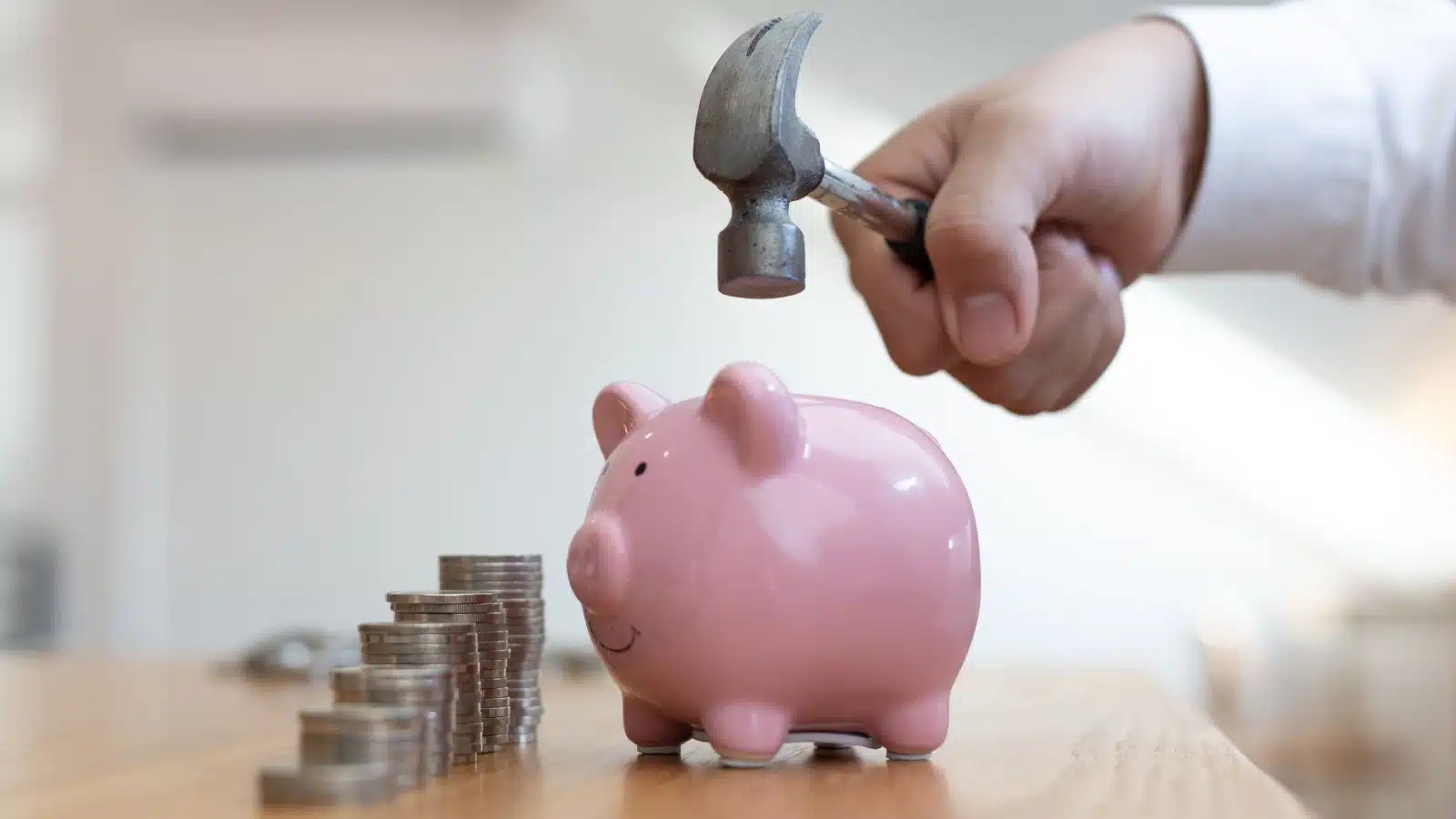 A person breaks open a piggy bank to represent a financial emergency.