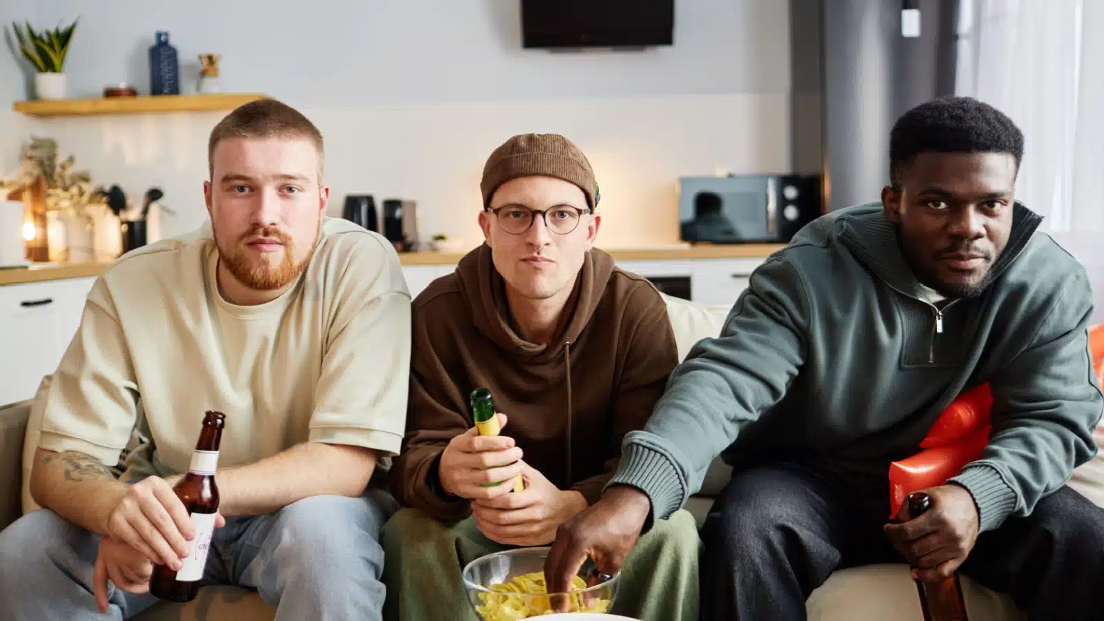 Front view of a group of friends watching live television together.