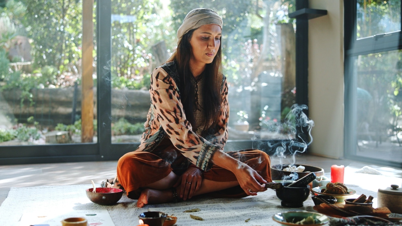 An eclectic witch does a magic ritual in her living room.