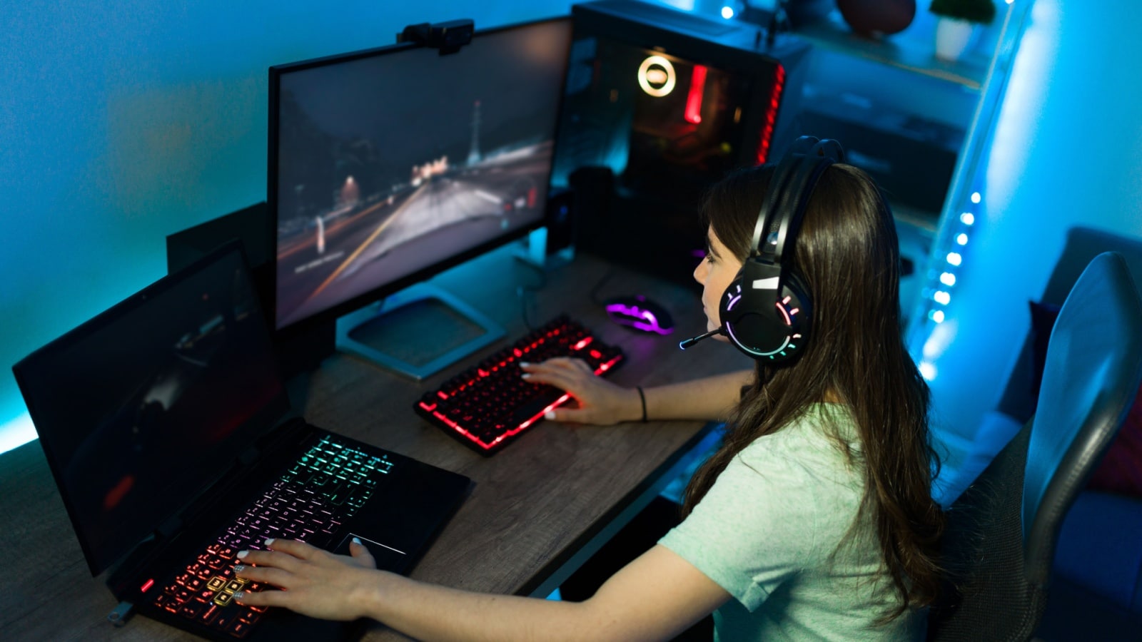 A girl gaming in front of her gaming pc set up. 