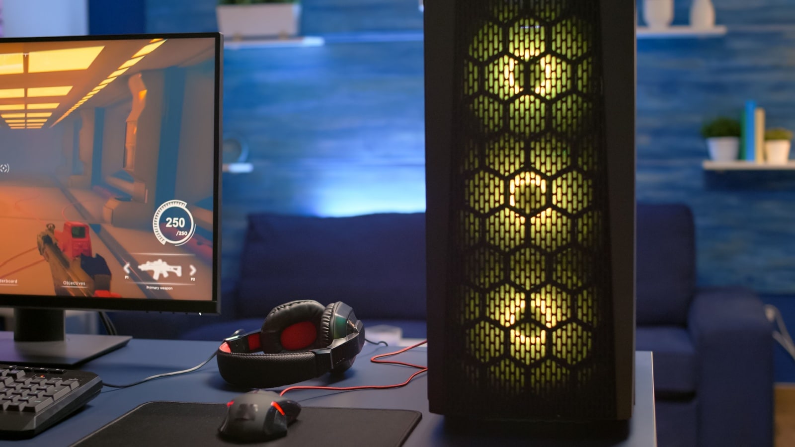 Close up of a gaming set up showing a mouse, monitor, head set, and gaming tower. 