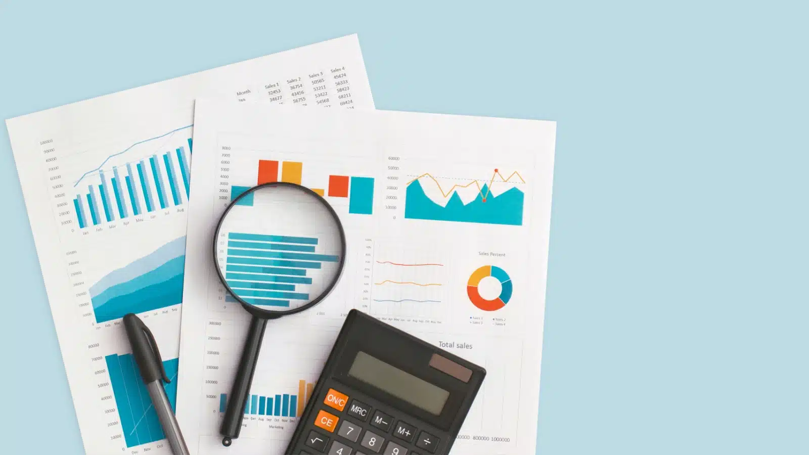 Investment charts and financial statements lay on the table with a magnifying glass and calculator.