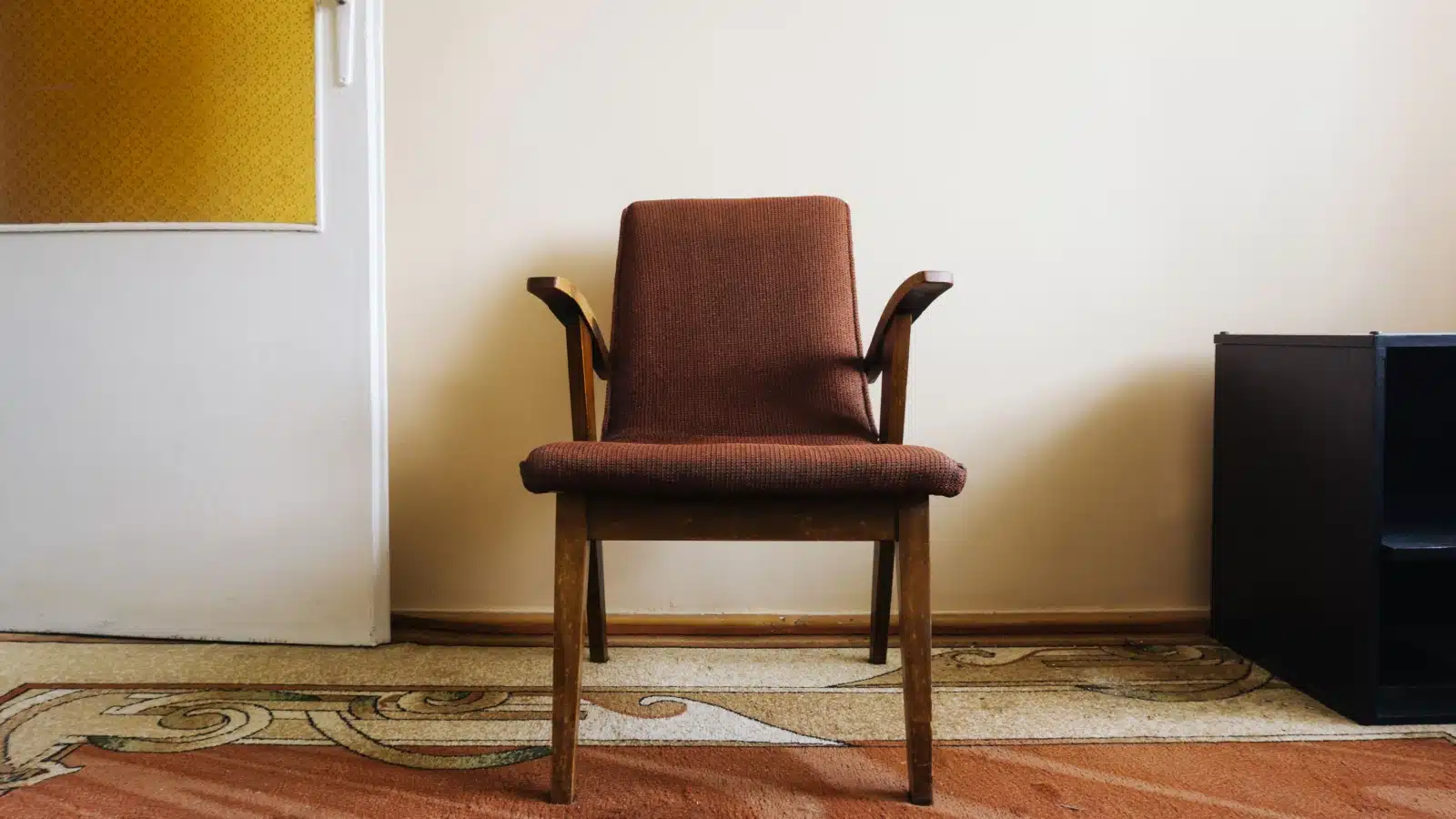 An old chair in an empty room represents absence.