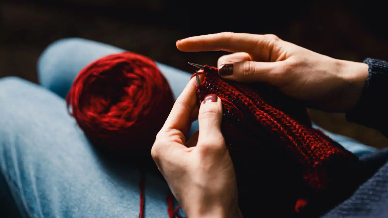 A woman knitting represents hand made gift ideas.