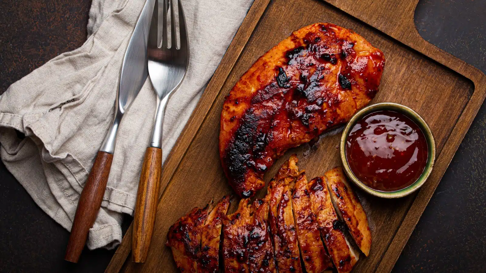 BBQ chicken breast on a cutting board.