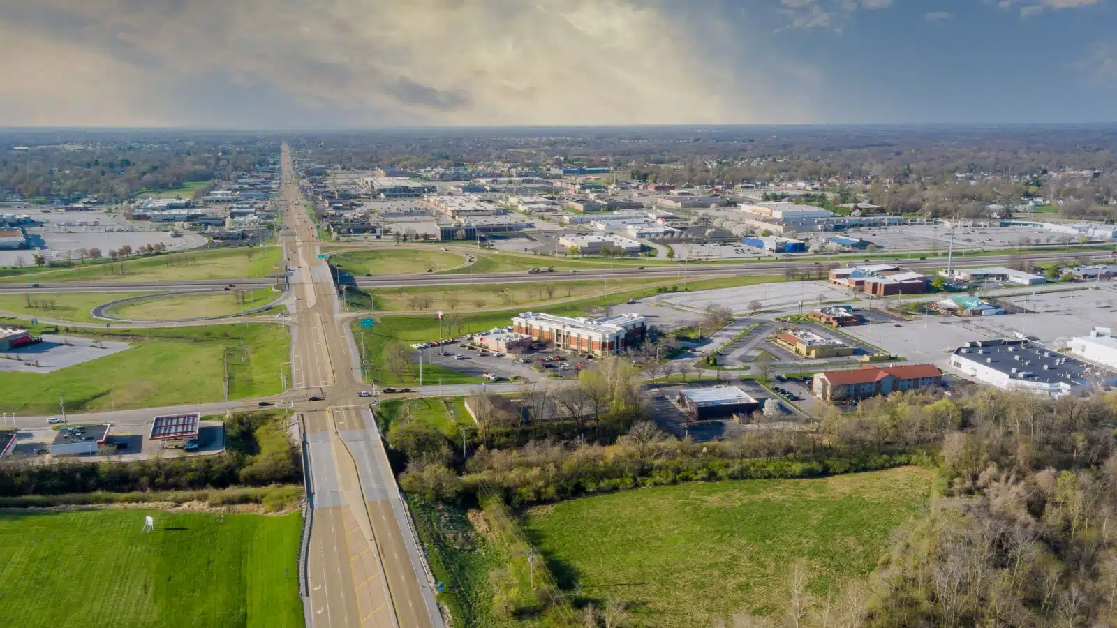Aerial view of a road leading to a small town in the middle of USA farmland.