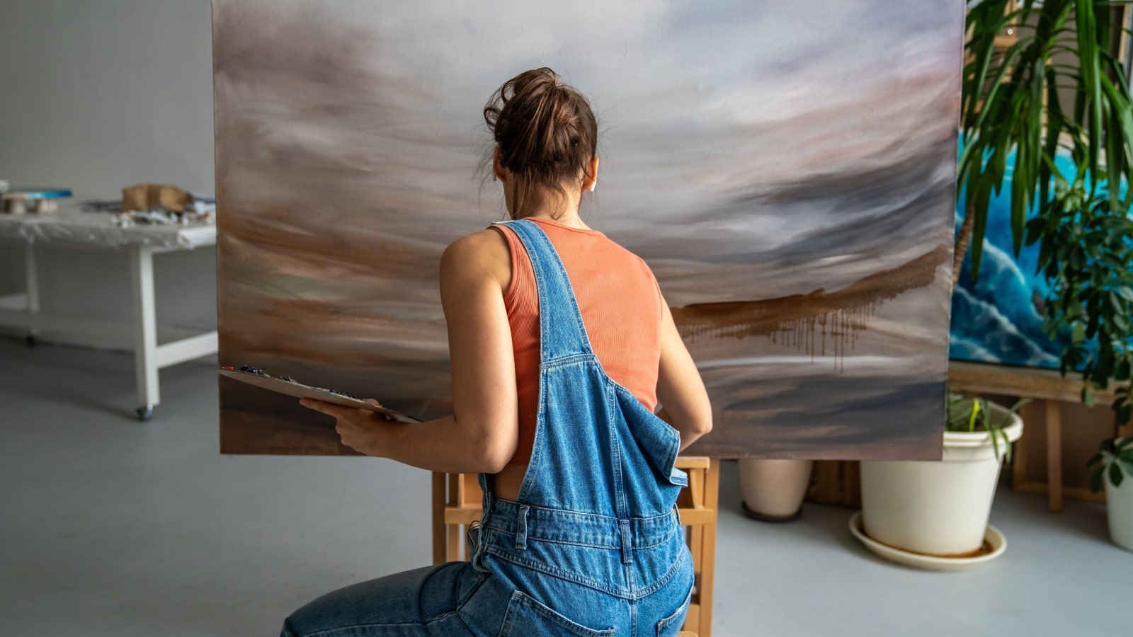 A woman creates a work of abstract art in her studio.