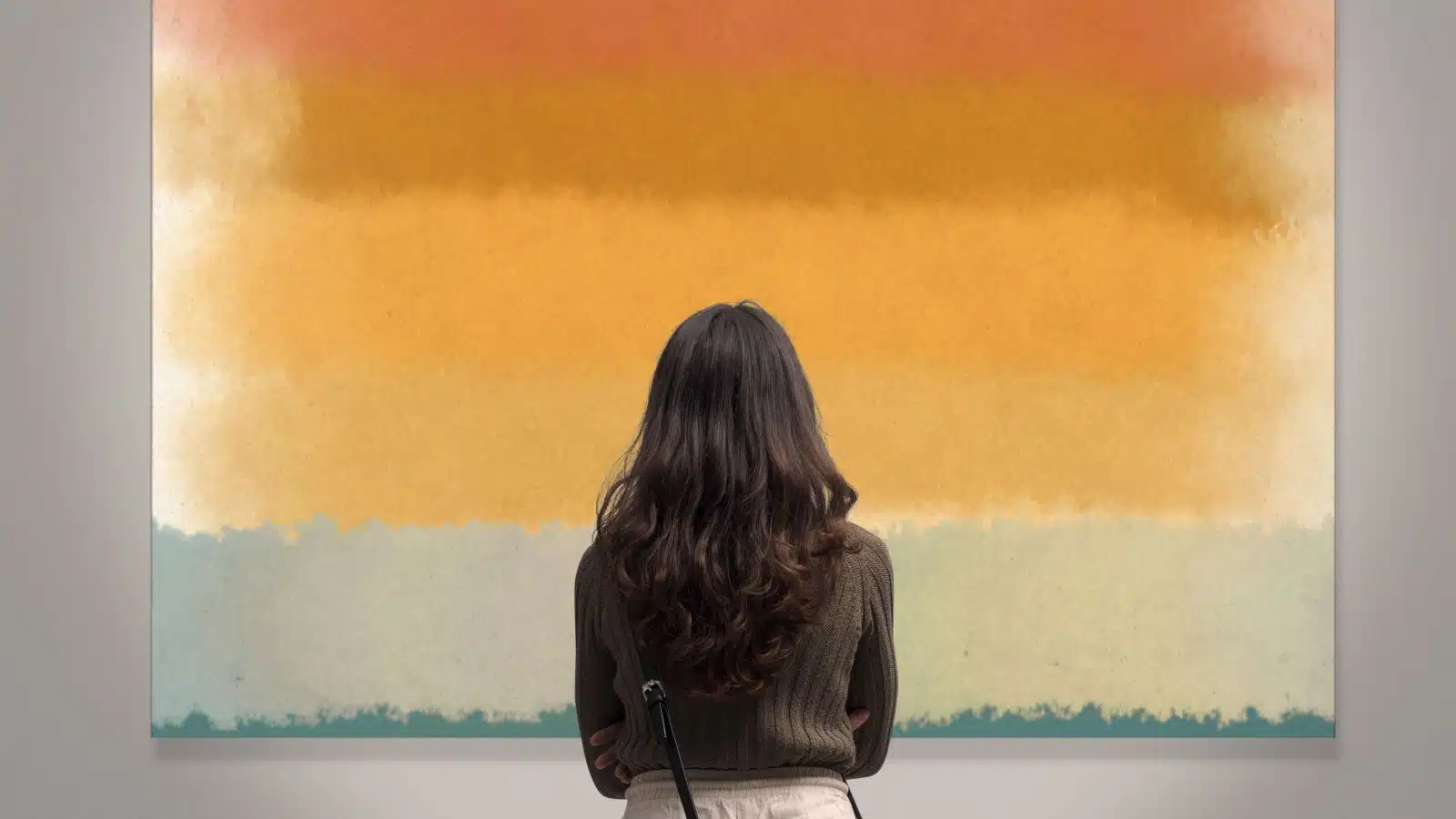 A woman looks at an abstract painting in an art gallery.