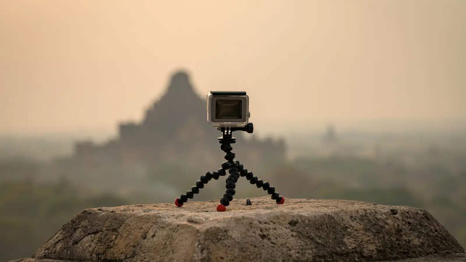 An action camera set up on a small tripod outside.