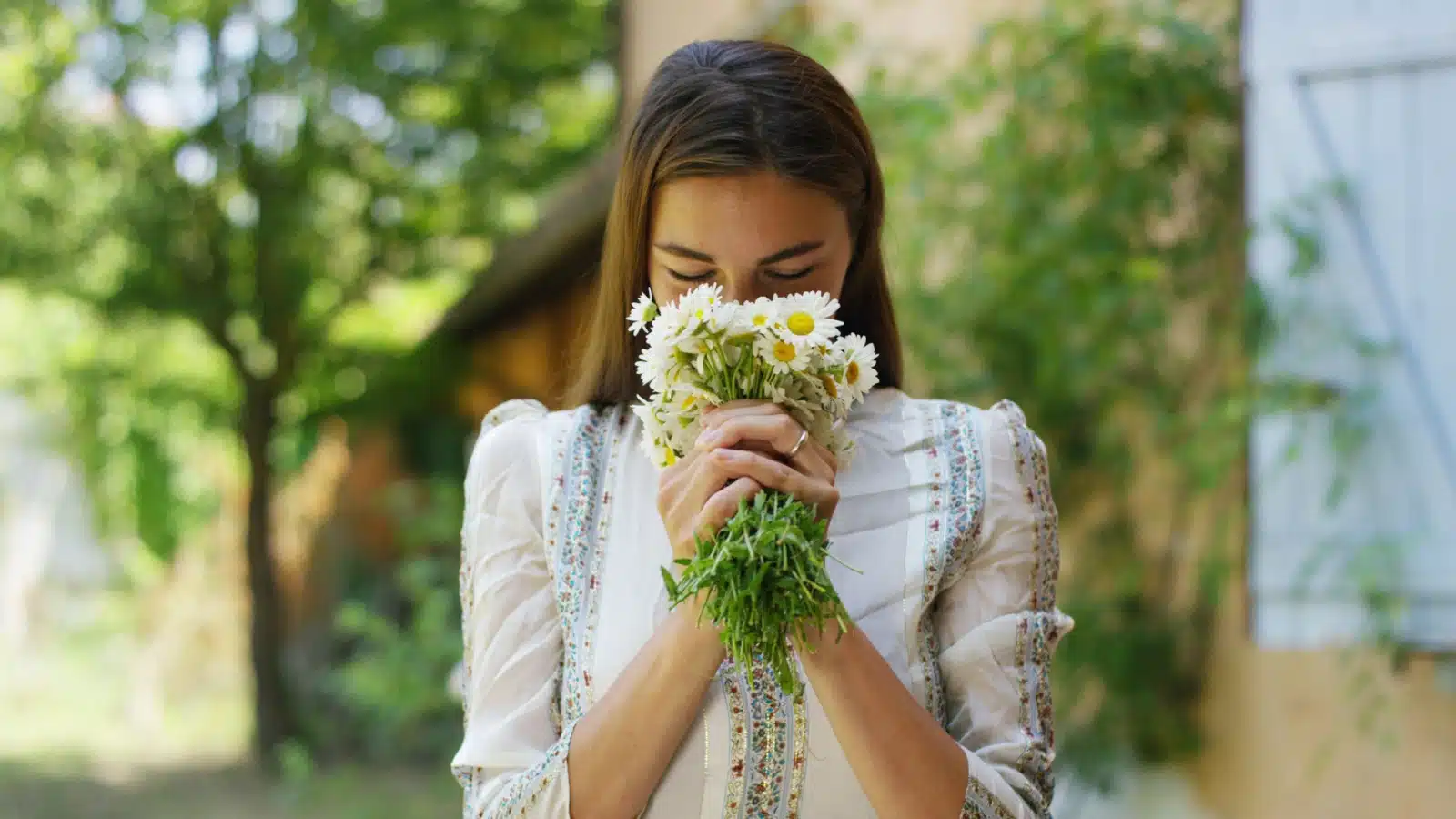 A woman with her face buried in a bouquet of fresh flowers in the spring, to represent the best smells in the world.