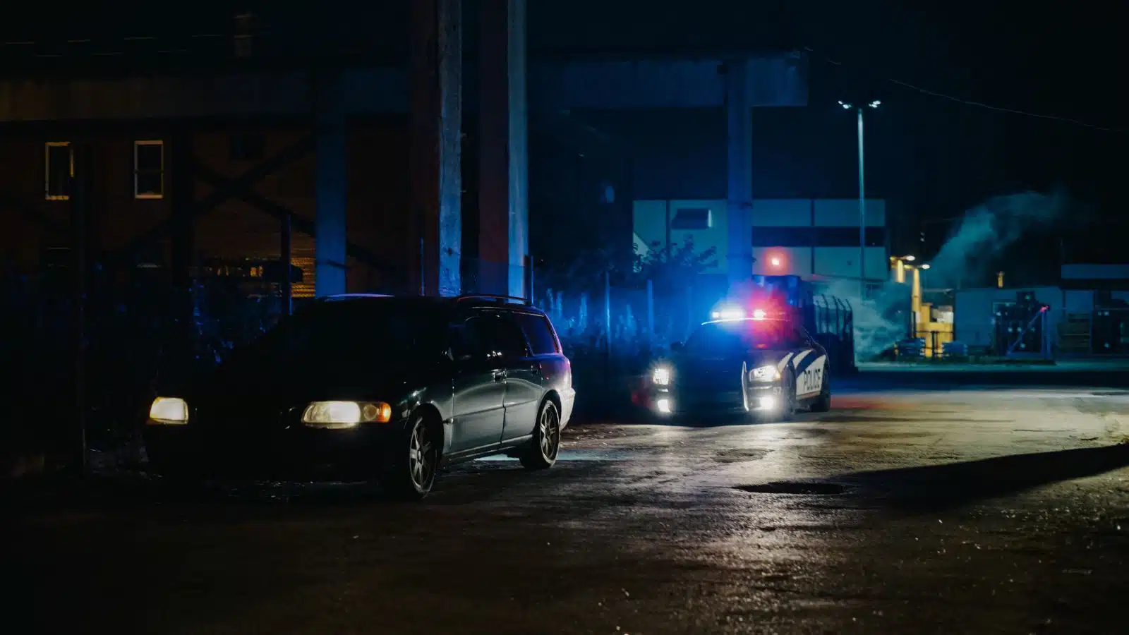 A police car pulls over an SUV at night.