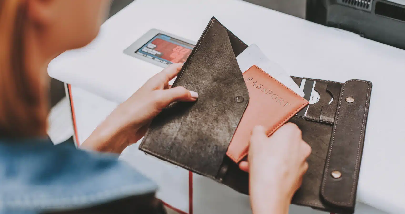 An agent taking a passport out of a travel document holder.
