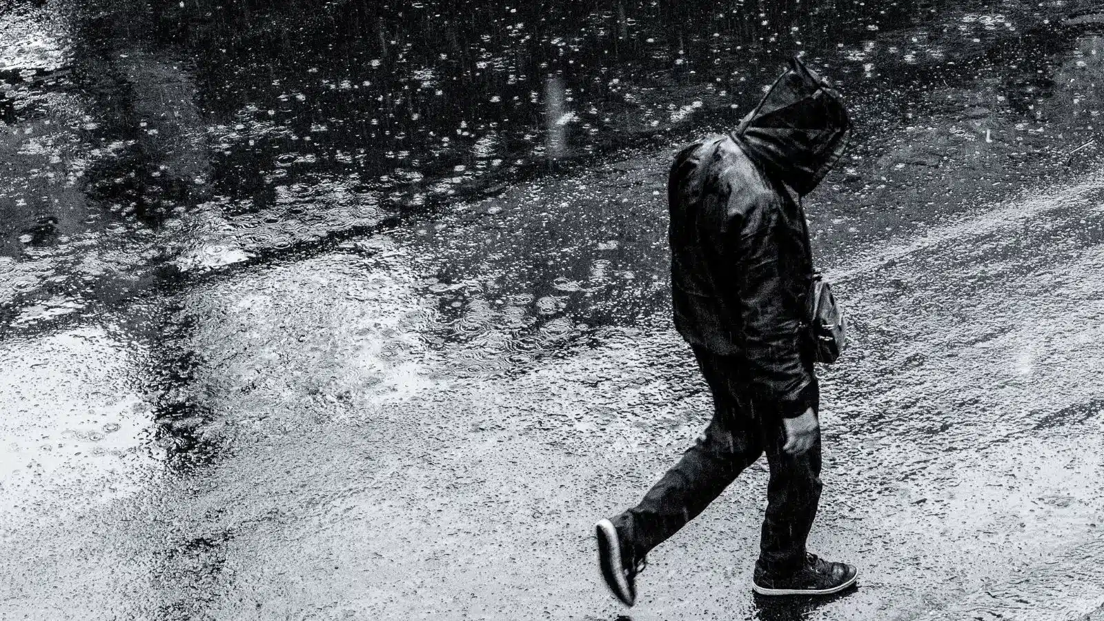 A man walks alone with his head down.