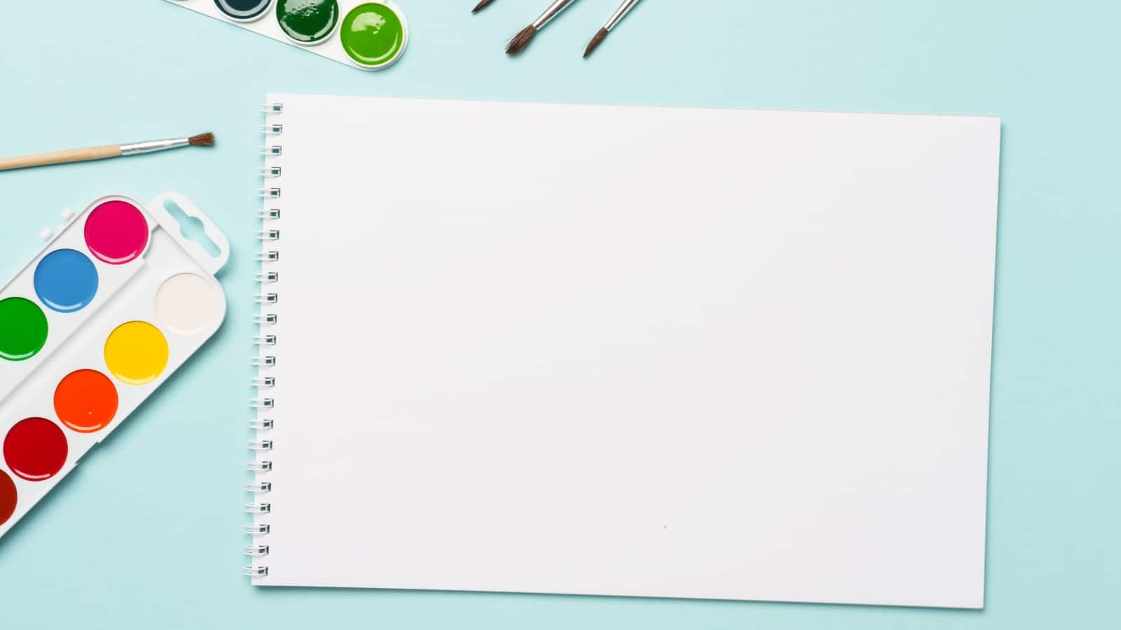 Pad of watercolor paper on a blue background. 