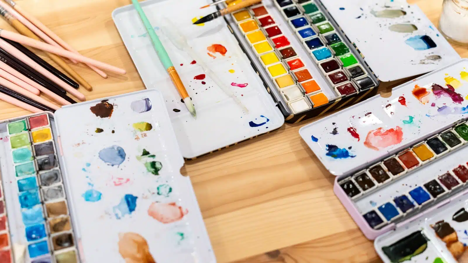 Watercolor supplies include the paints, palettes, and brushes.