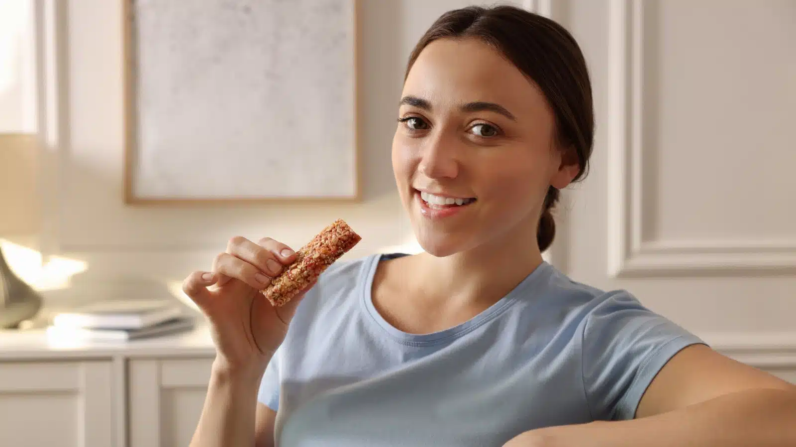 A woman eats a breakfast bar to represent healthy things that are bad for you.