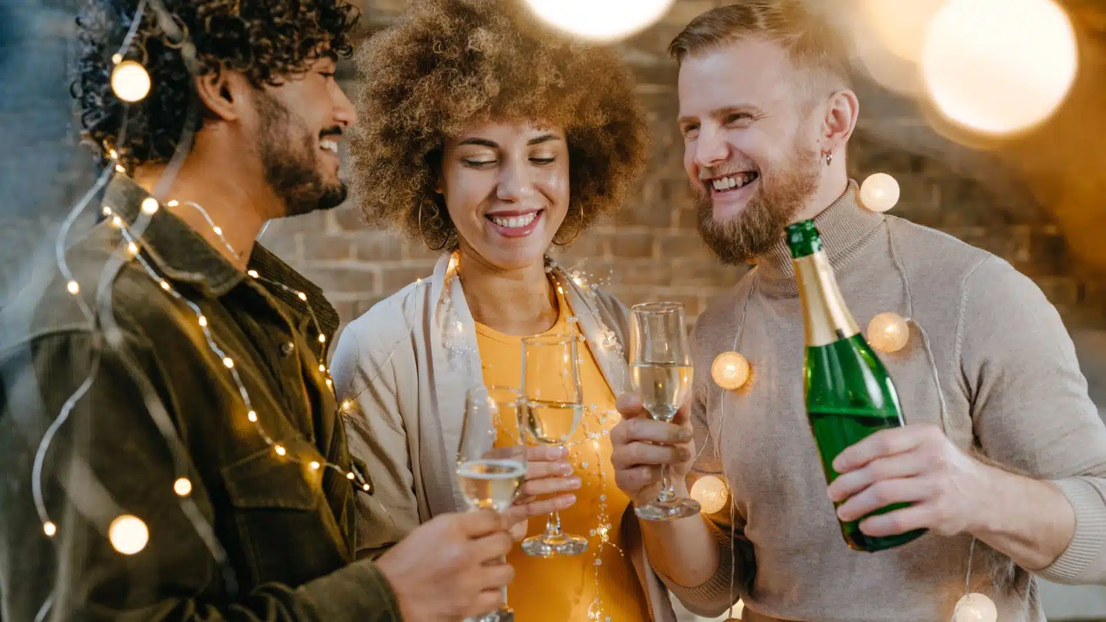 Three friends pour champagne to toast to the New Year.