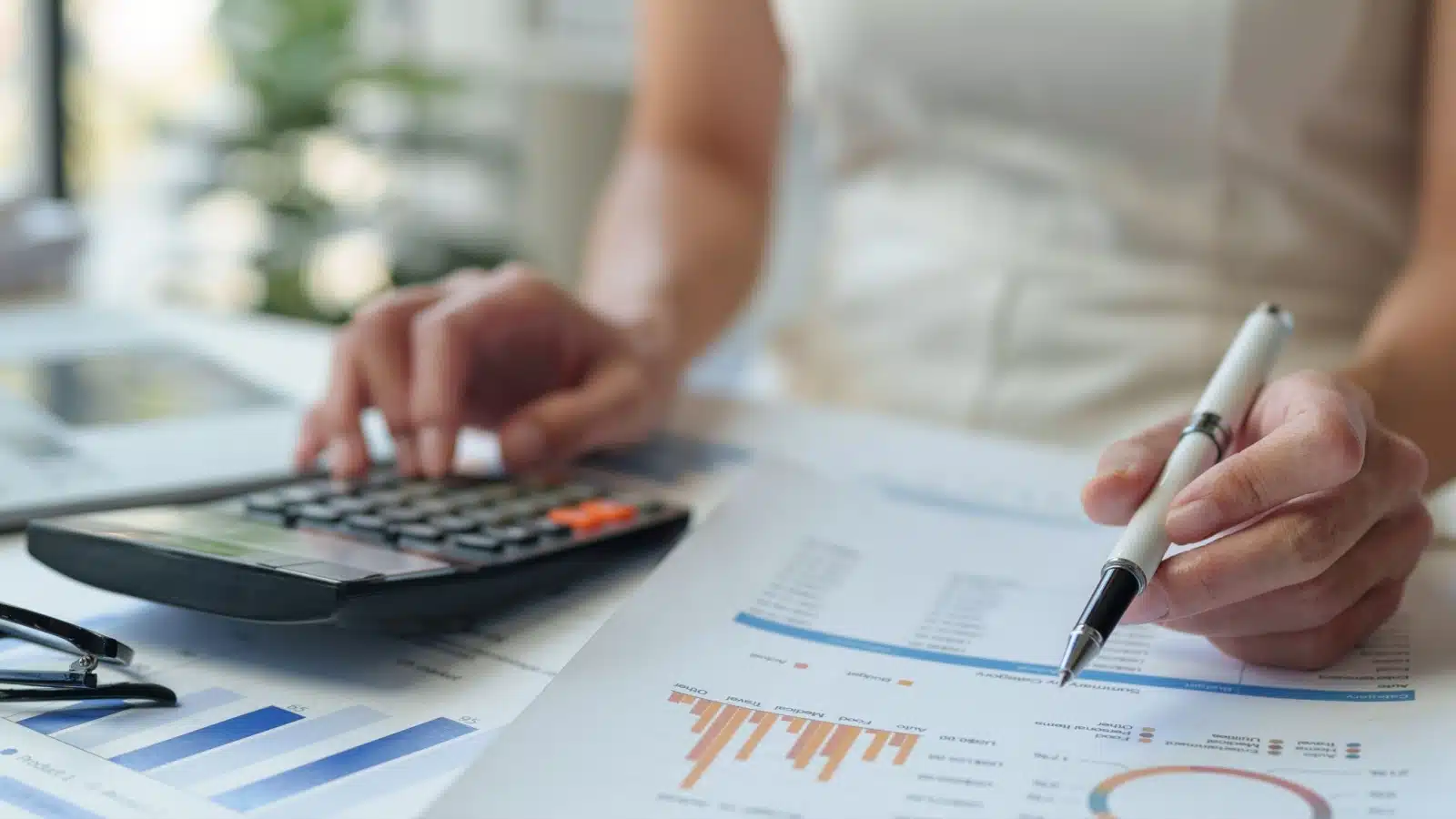 Close up of a woman using a calculator to understand her financial life.