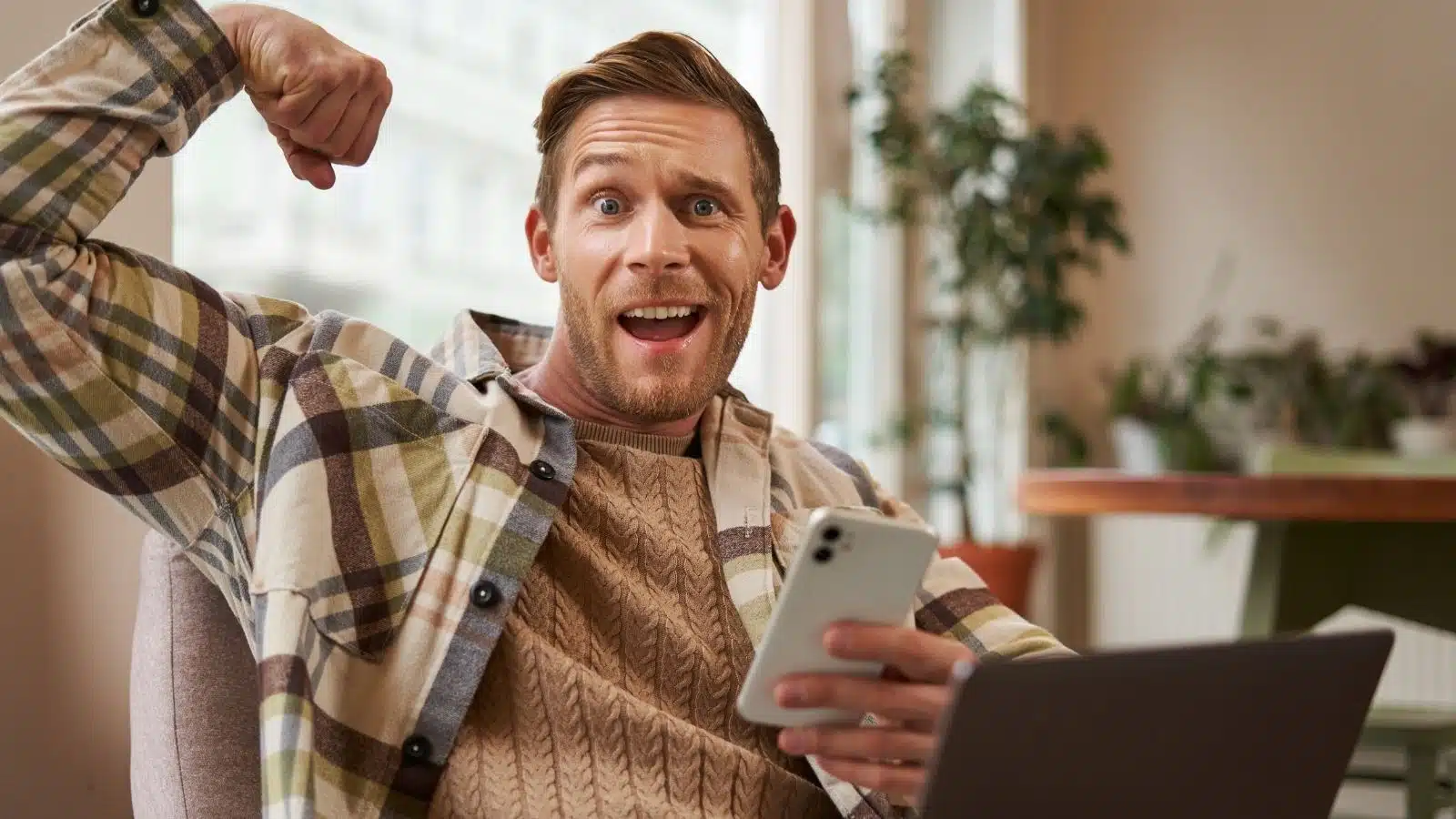 A silly looking man flexes his arm while looking at his phone. His silly pose makes everyone else think it's not the flex you think it is.