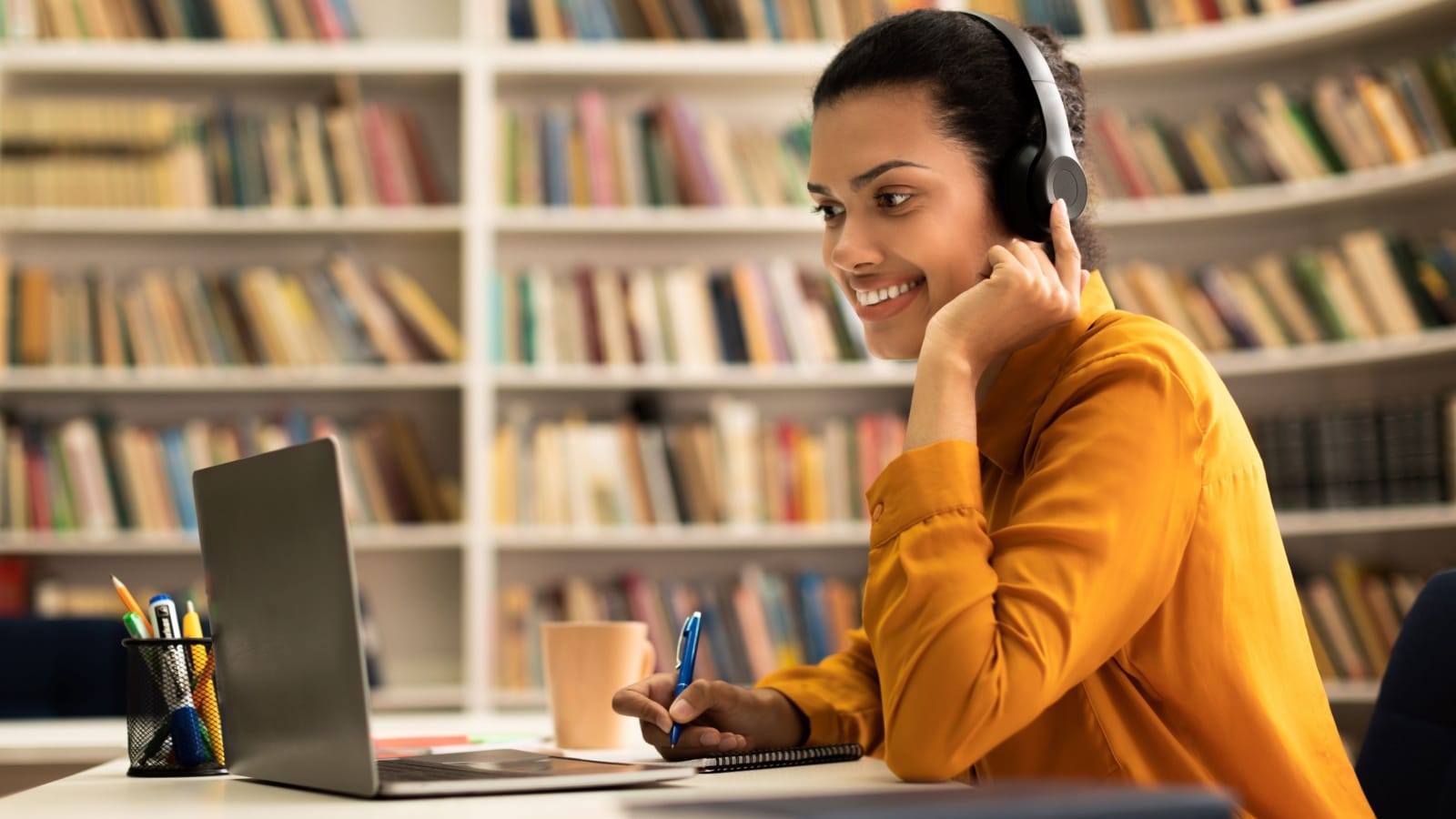 A woman takes an online class in a library. 