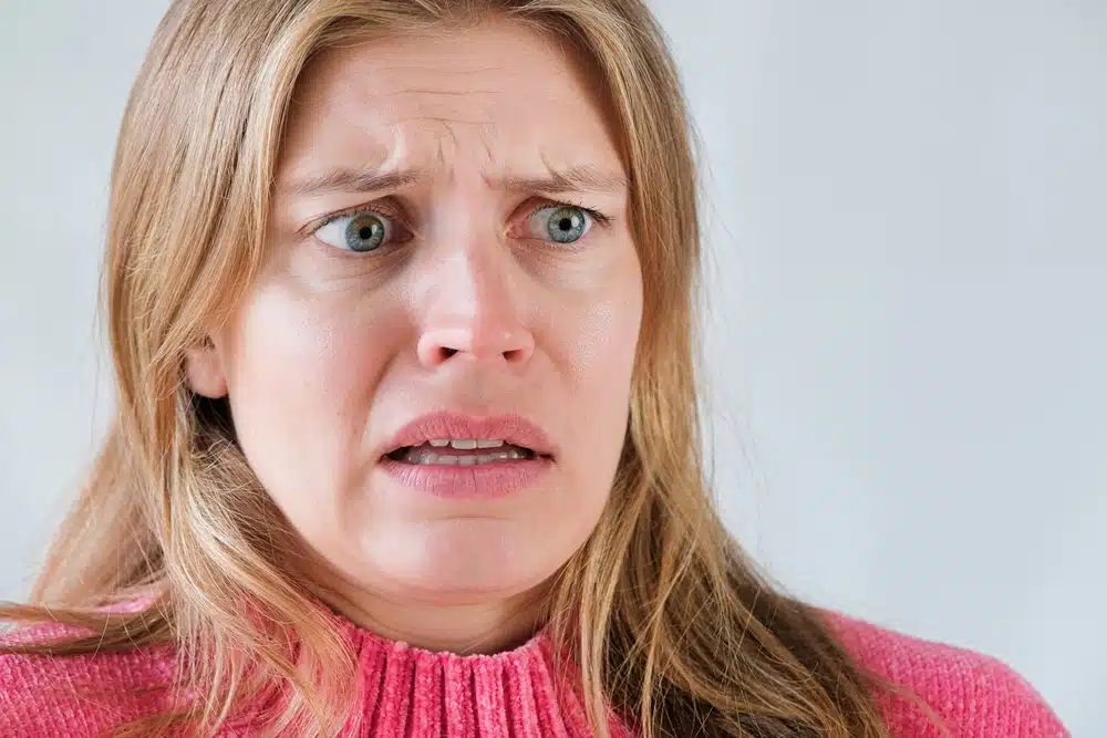 Close up of a woman's face who is shocked and disgusted.