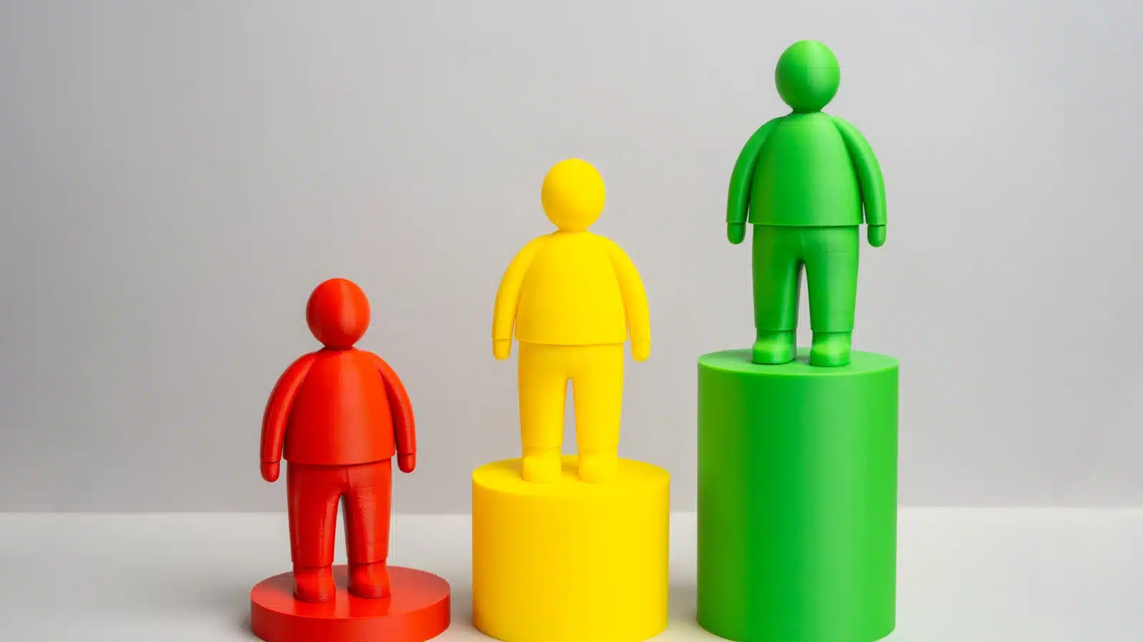 Concept art representing social status. Three different colored human shaped molds stand at different heights.