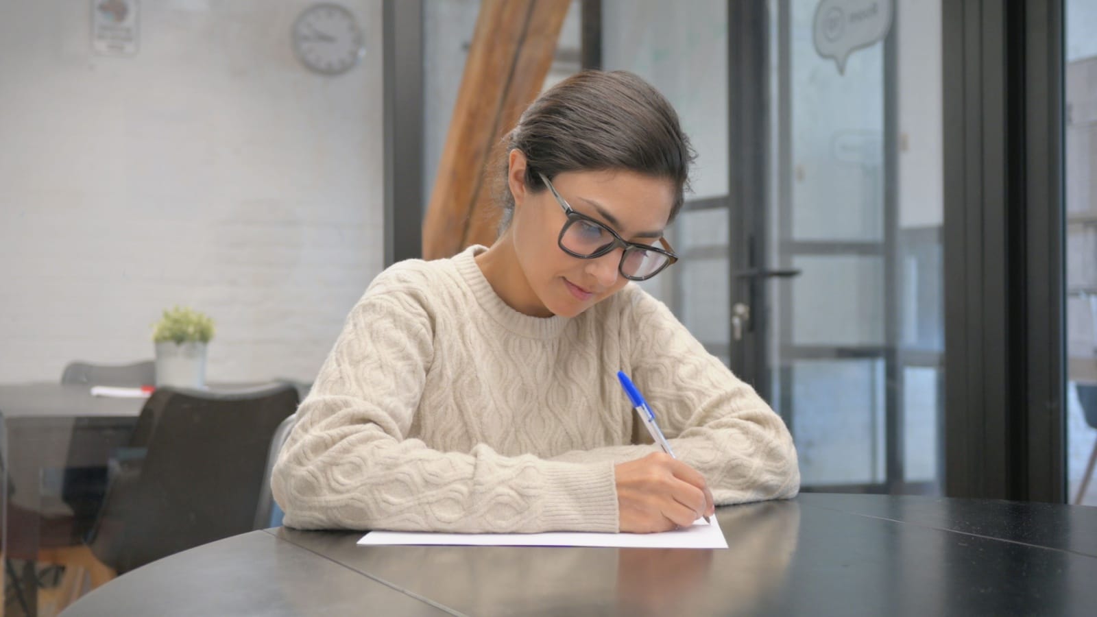 A woman writing on a blank page by hand to represent free writing. 
